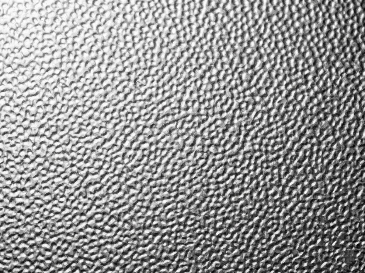 Close-up of a hammered stucco aluminum texture